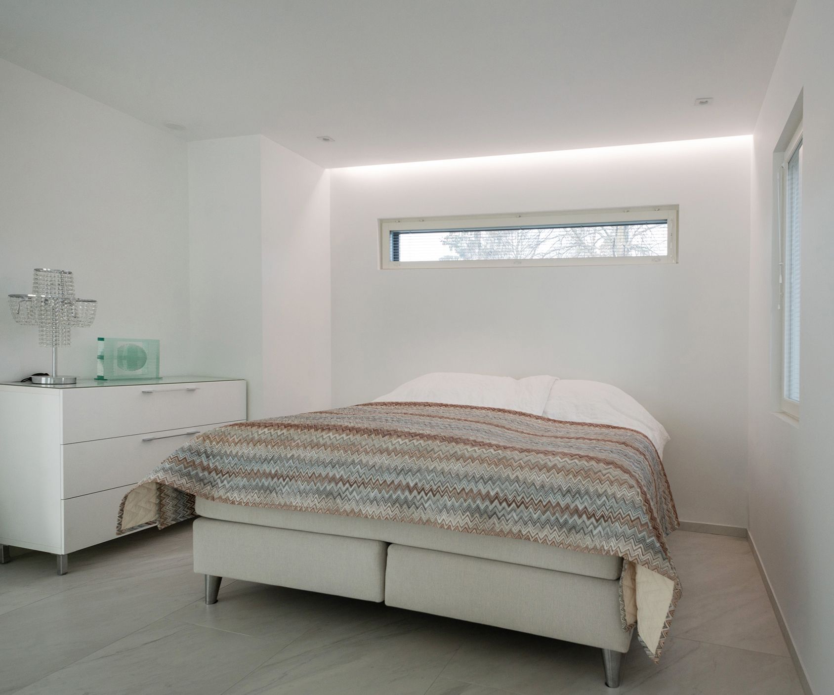 Pleasantly soft mood lighting on the wall behind the bed in the bedroom. Led strip mounted in a groove between the ceiling and the wall. Ledstore.fi